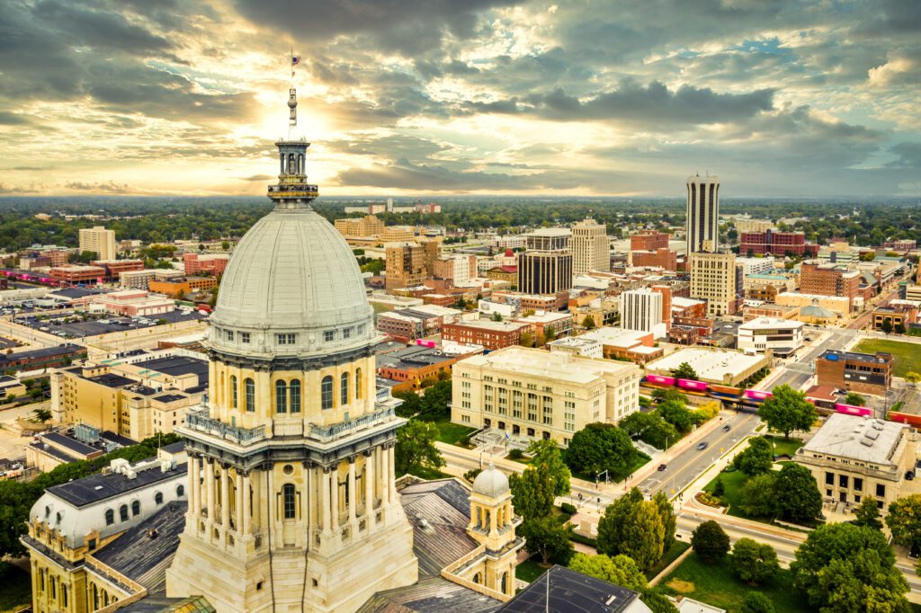 Illinois State Capitol and Springfield skyline at sunset.